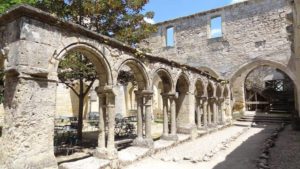 Ancient stone convent in Saint Emilion, featuring arches and remnants of the historic structure, a significant landmark on the Bordeaux wine tour.