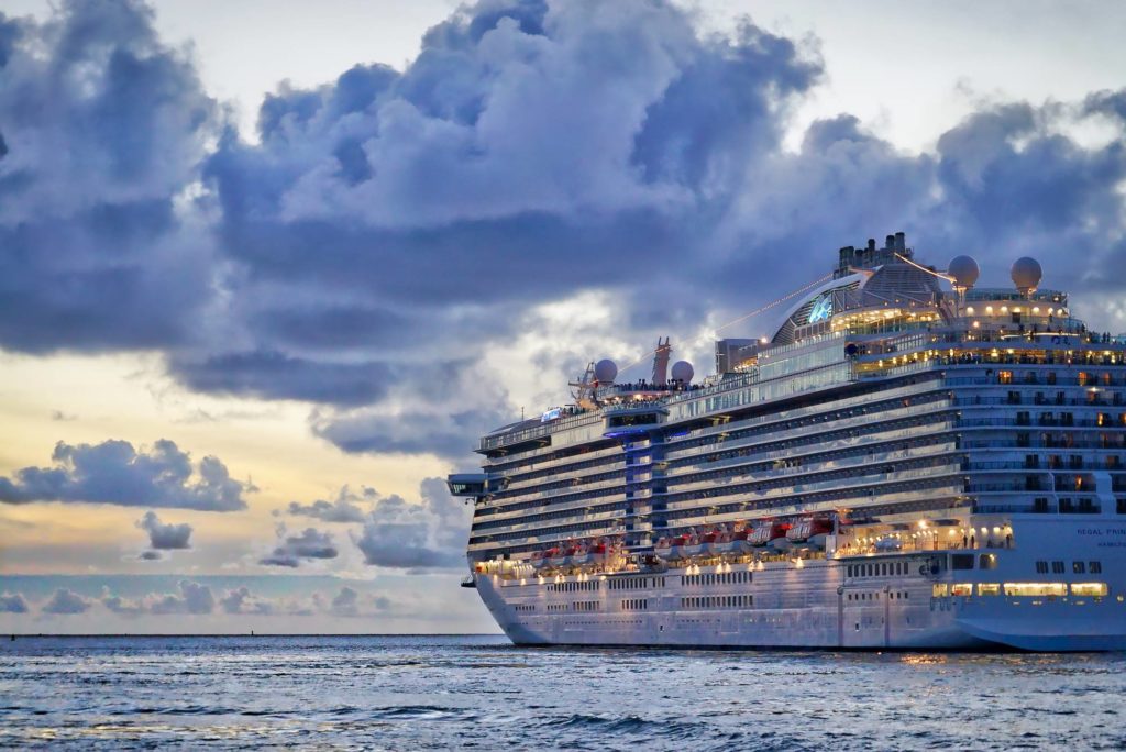 Large cruise ship docked under a dramatic cloudy sky, ready to offer passengers custom Bordeaux wine tours during their shore excursion.